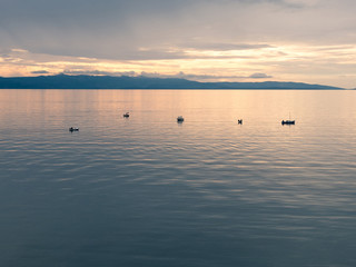 Small traditional fishing boats on calm sea at sunset