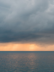 Fototapeta premium Horizon over blue sea with dark clouds above