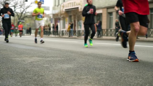 blurred crowd of people running on asphalt road at city marathon