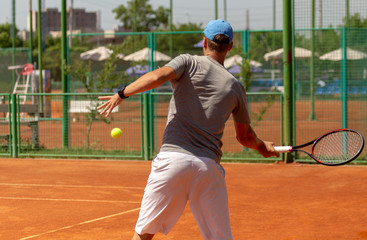A man plays tennis on the court in the park