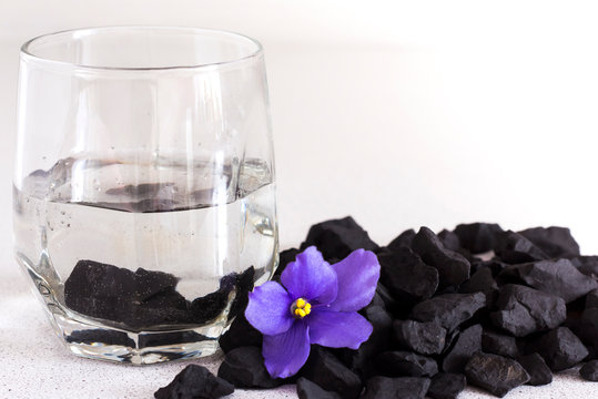 Shungite stones in a glass of water for cleaning and feeding water ,close-up
