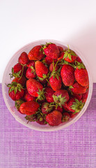 bucket of red ripe strawberries on abstract background with copy space