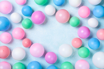 Colorful balloons on blue table top view. Birthday or party background. Flat lay style.