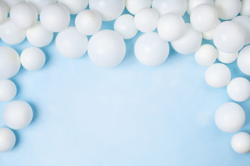 Fototapeta premium Pastel blue table with white balloons top view. Party or birthday background. Flat lay style.