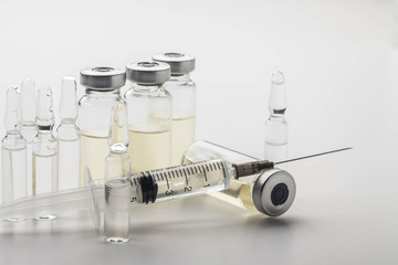 Subcutaneous syringe. Syringes with blue needles. Medical Injectors. Medical glass injection bottle. Ampoules with injections.