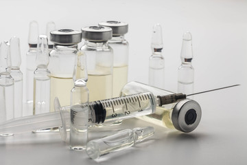 Subcutaneous syringe. Syringes with blue needles. Medical Injectors. Medical glass injection bottle. Ampoules with injections.