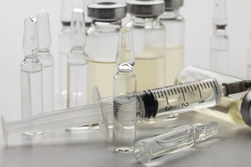 Subcutaneous syringe. Syringes with blue needles. Medical Injectors. Medical glass injection bottle. Ampoules with injections.