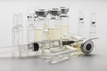Subcutaneous syringe. Syringes with blue needles. Medical Injectors. Medical glass injection bottle. Ampoules with injections.