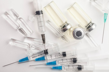 Subcutaneous syringe. Syringes with blue needles. Medical Injectors. Medical glass injection bottle. Ampoules with injections.