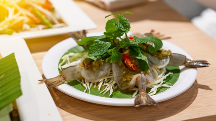 Shrimp soaked in fish sauce in a white dish