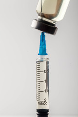Medical syringe and vial for intravenous administration of the drug on a light background
