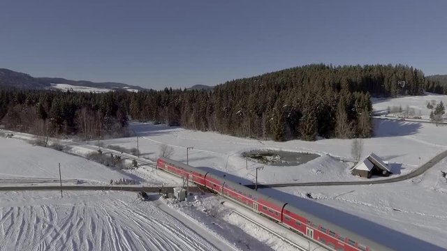 black forest in germany with snow passing a passenger train images with drone