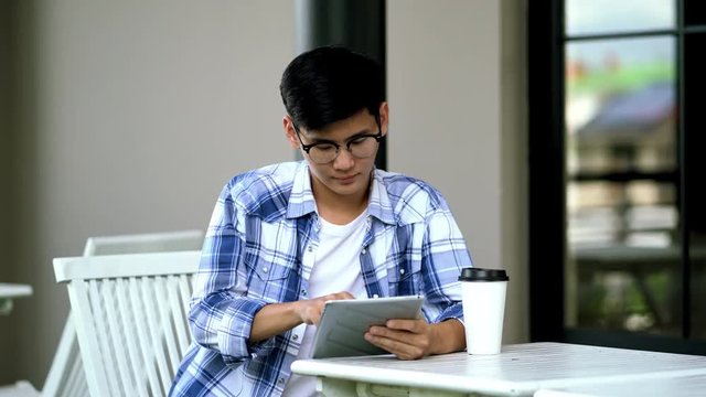 Young man using tablet in hand looking camera and smile