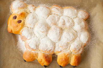 Vegan easter lamb based on yeast dough decorated with powdered sugar and raisins