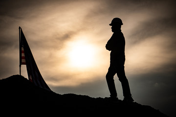 Concept Labor Day: Labor man standing with a warm sunset light