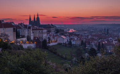 Fototapeta na wymiar A beautiful spring view of Prague at sunrise from Petrin hill. Prague Castle and St. Vitus Cathedral on the left and a golden rising sun in the background