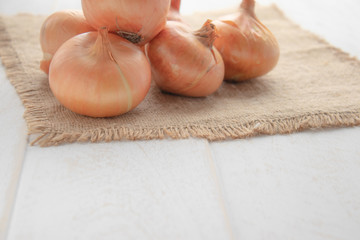 Yellow onions on burlap. Autumn harvest, vegetarianism, food, vegetables.