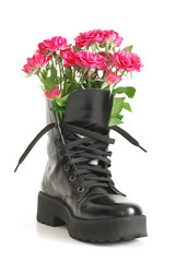 Bunch of pink roses in black combat boot