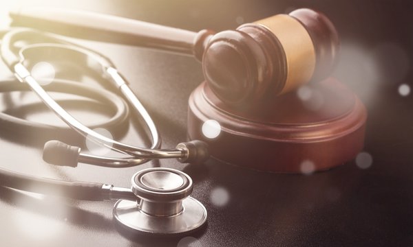 Wooden gavel and stethoscope close-up view