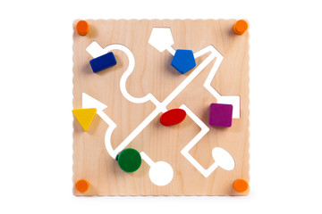 Сlose-up of a labyrinth with multi-colored puzzles on a wooden busy board- educational toy for children, babies on a white isolated background. A toy for entertaining children and resting parents