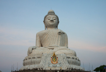 Fototapeta premium Big Buddha sculpture. Beautiful religious sculpture from white nephrite on a light sky background.