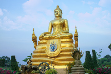       Golden Buddha sculpture. Beautiful religious sculpture in the garden the backdrop of a light cloudy sky.