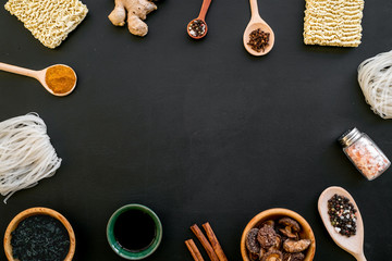 Rice vermicelli, noodles, spices, weeds pattern to cook Chinese and Japanese food black background top view copy space