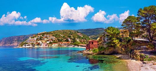Beautiful landscape with bay and colorful buildings on the background of picturesque clouds in the town of Asos, Greece, Kefalonia. Wonderful exciting places. - obrazy, fototapety, plakaty