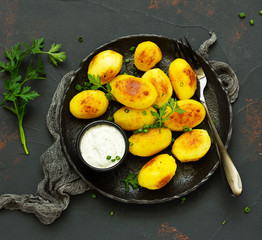 baked young potatoes with white sauce. View from above.