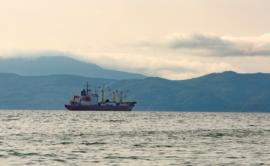 Obraz premium fishing boat in gray morning on Pacific ocean off the coast of the Kamchatka Peninsula