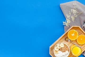Bright breakfast with granola and orange juice on blue background top view mockup