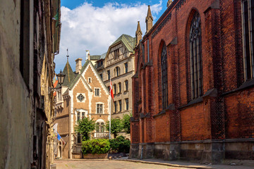 Narrow cobblestone street in old town of Riga city, Latvia. Summer sunny day.