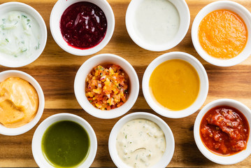 Bowls with sauces on wooden tray