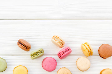 Macarons dessert pattern on white wooden background top view copy space