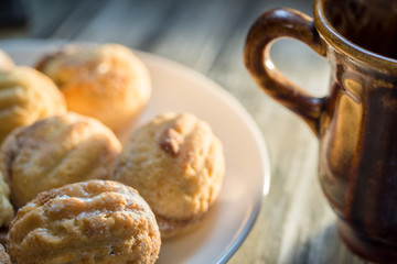 Morning coffee with cream cookies, close-up in the sunlight