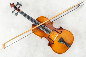 Fototapeta na wymiar top view of classical cello with bow on grey background