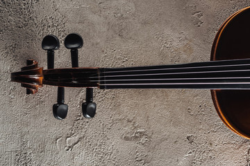 top view of strings of cello on grey textured surface