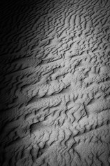 beautiful natural wavy lines carved into the sand by the wind in Bolonia, Spain in black and white 