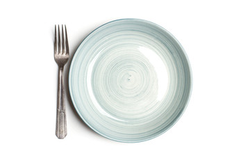 Plato redondo celeste con tenedor sobre un fondo blanco. Vista superior. Copy space