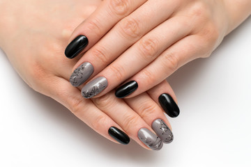 Obraz na płótnie Canvas black-gray manicure with a cobweb on short oval nails with stones on a white background