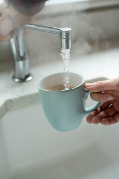 Close Up Of Man Making Hot Drink From Boiling Water Tap