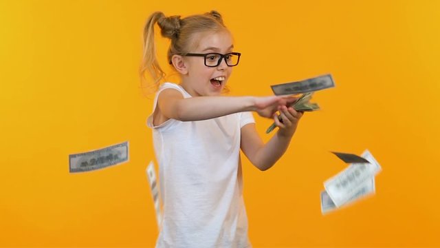 Excited kid throwing money, celebrating victory at talent show, jack-pot winner