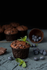 Chocolate muffins with blueberries on a dark background. Chocolate brownies.