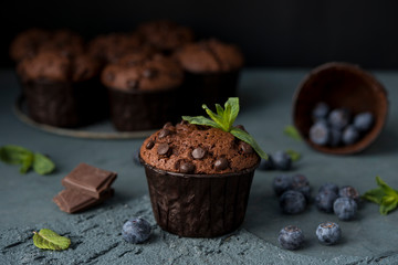 Chocolate muffins with blueberries on a dark background. Chocolate brownies.