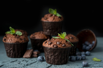 Chocolate muffins with blueberries on a dark background. Chocolate brownies.