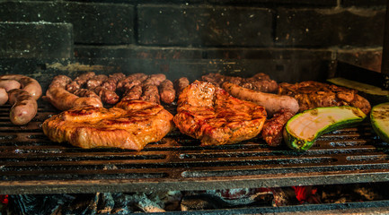 Juicy pork steaks, sausages and minced meat cevapcici on charcoal barbecue.