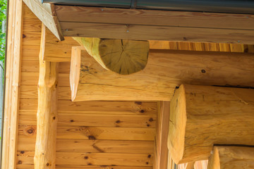 Wooden logs house roof and wall connection detail closeup.