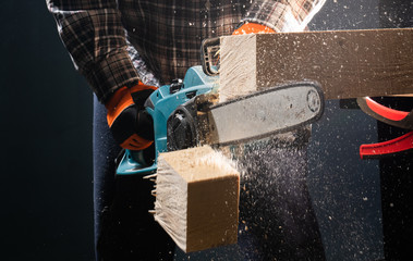 Man using modern electric circular saw in the workshop