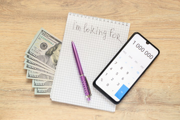 Notepad with the inscription I'm looking for  and US dollars with   smartphone open calculator with numbers 1 000 000 on the background of a desk