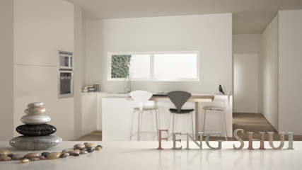 White table shelf with pebble balance and 3d letters making the word feng shui over modern minimalist white kitchen with island, stools and windows, zen concept interior design